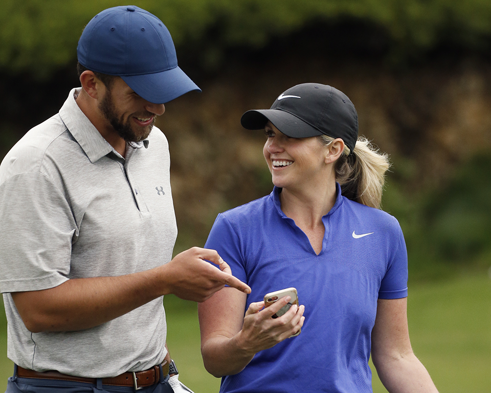 Two players looking at the Toptracer app on a smartphone