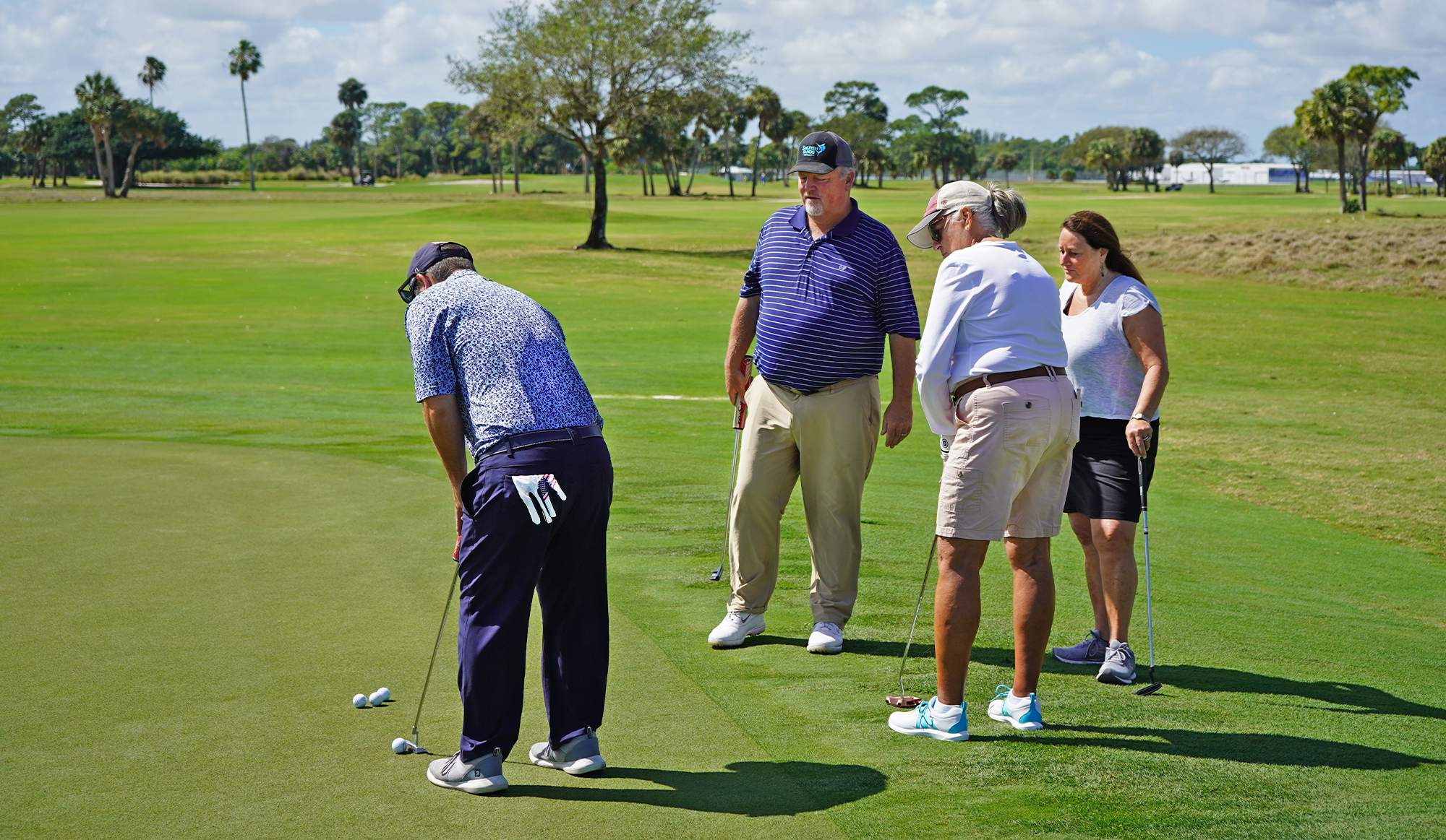 A group of golfers getting a lesson from a golf professional