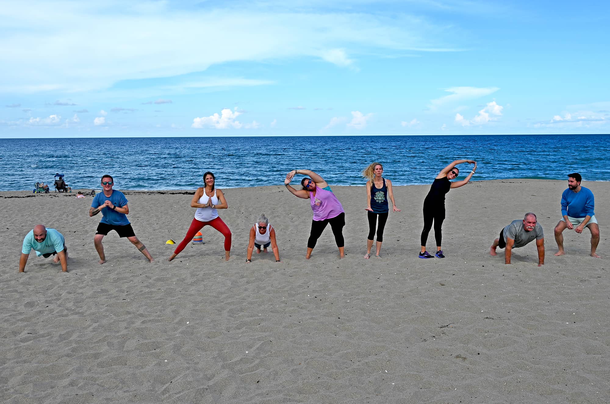 A group of people exercising on the beach