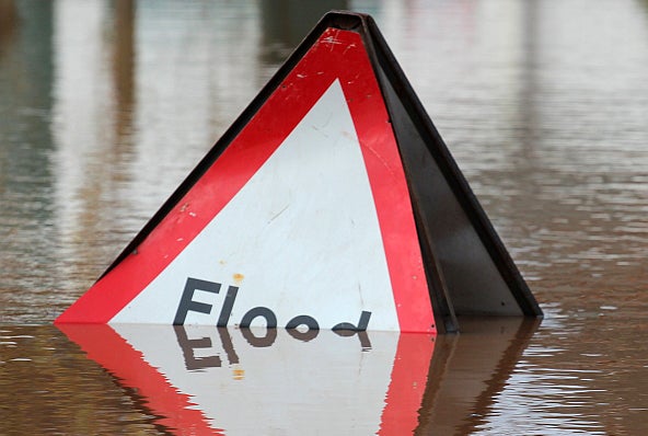A flood sign partially covered by water