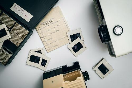 photo of slide negatives, hand-written notes, and projector