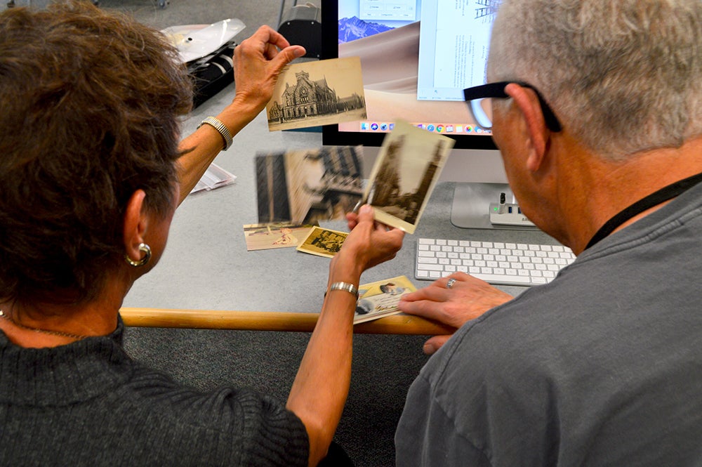 A volunteer and resident review historic photographs