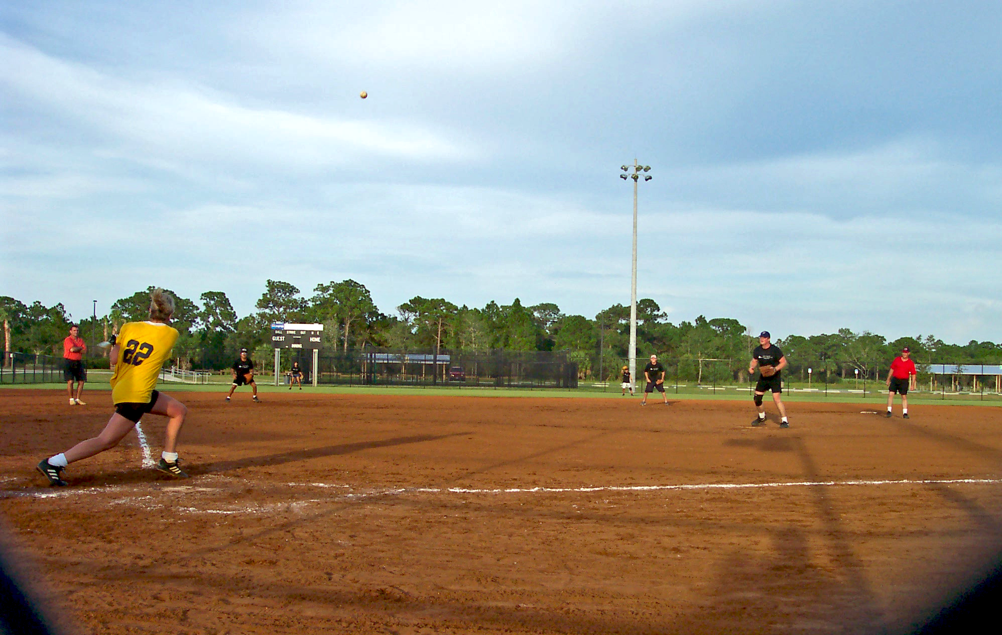 A woman swinging a bat during a softball game