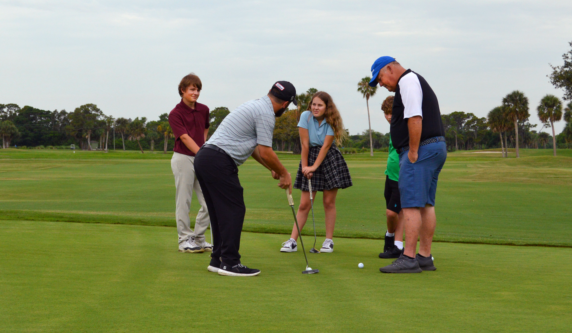 A family participating in golf lessons at Sailfish Sands Gold Course
