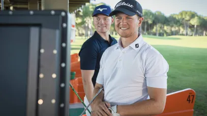 Two golfers looking at a Trackman screen