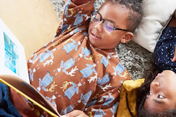 two children lying on their backs reading