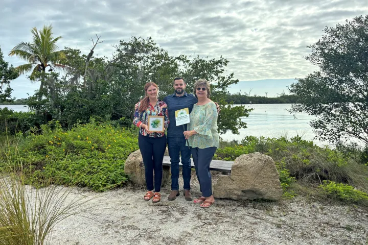 County staff posed together with the Garden of Excellence Award at the Ripple Eco-Art Project in the Old Palm City CRA.