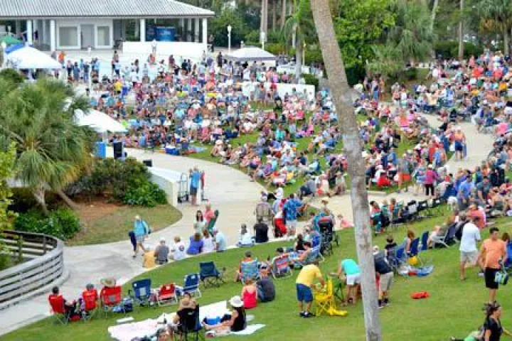 A crowd sitting on the lawn listening to music at the Mansion at Tuckahoe