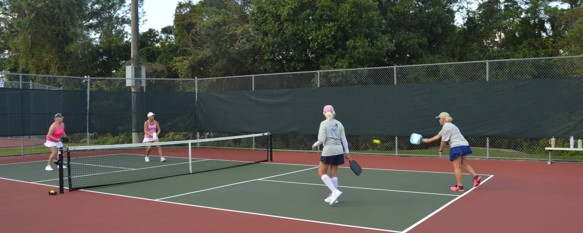 4 women playing pickleball