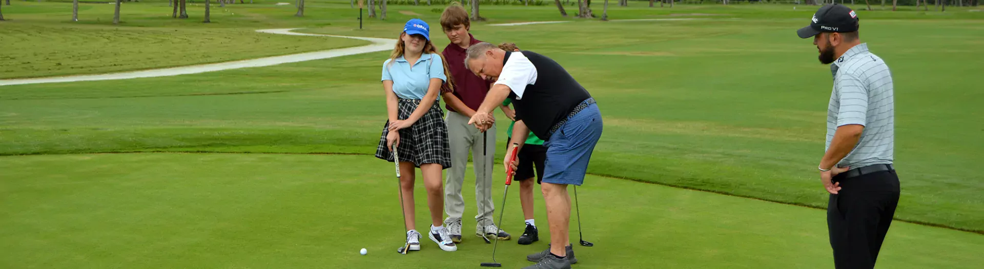 Instructors showing kids how to play golf