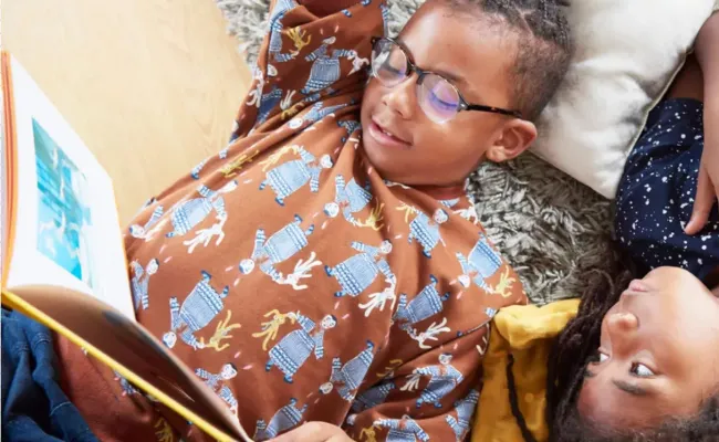 two children lying on their backs reading