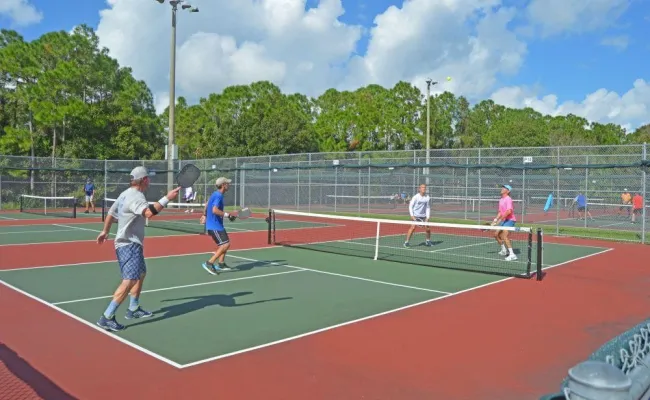 Four people playing pickleball. 