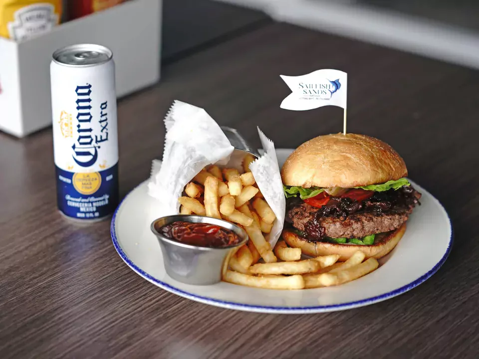 Image of a Sailfish Sands burger with a side of fries and Corona Extra