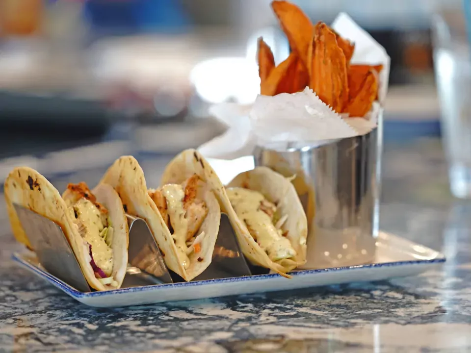 Image of three fish tacos with a side of sweet potato fries