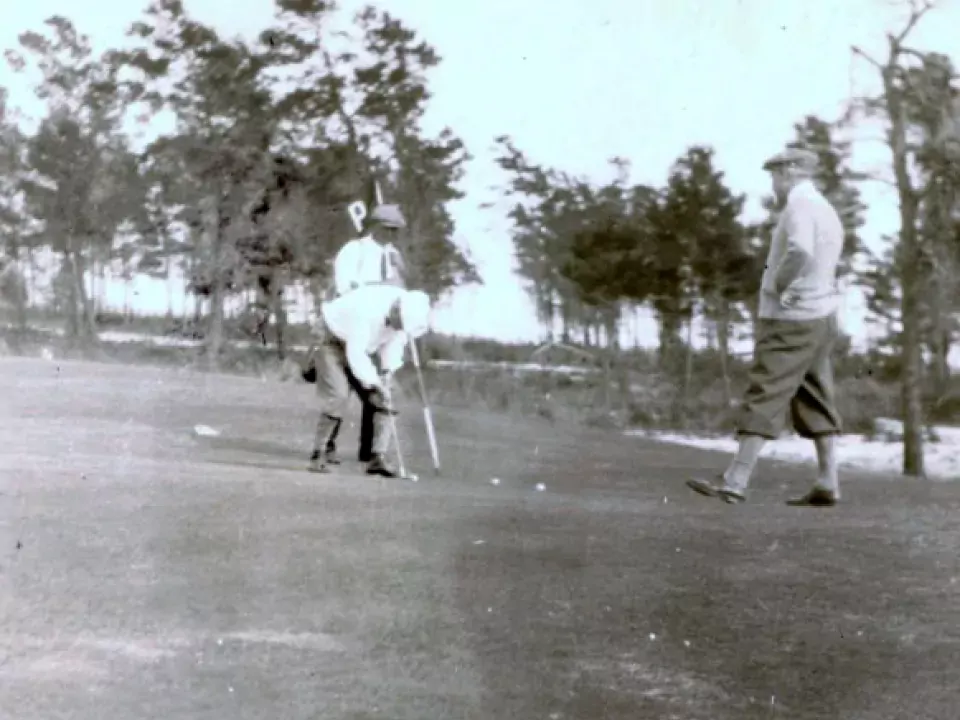 Golf course historical photo showing two men playing golf