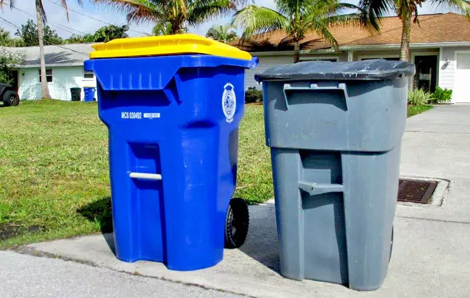 A blue recycling cart placed at the curb for collection