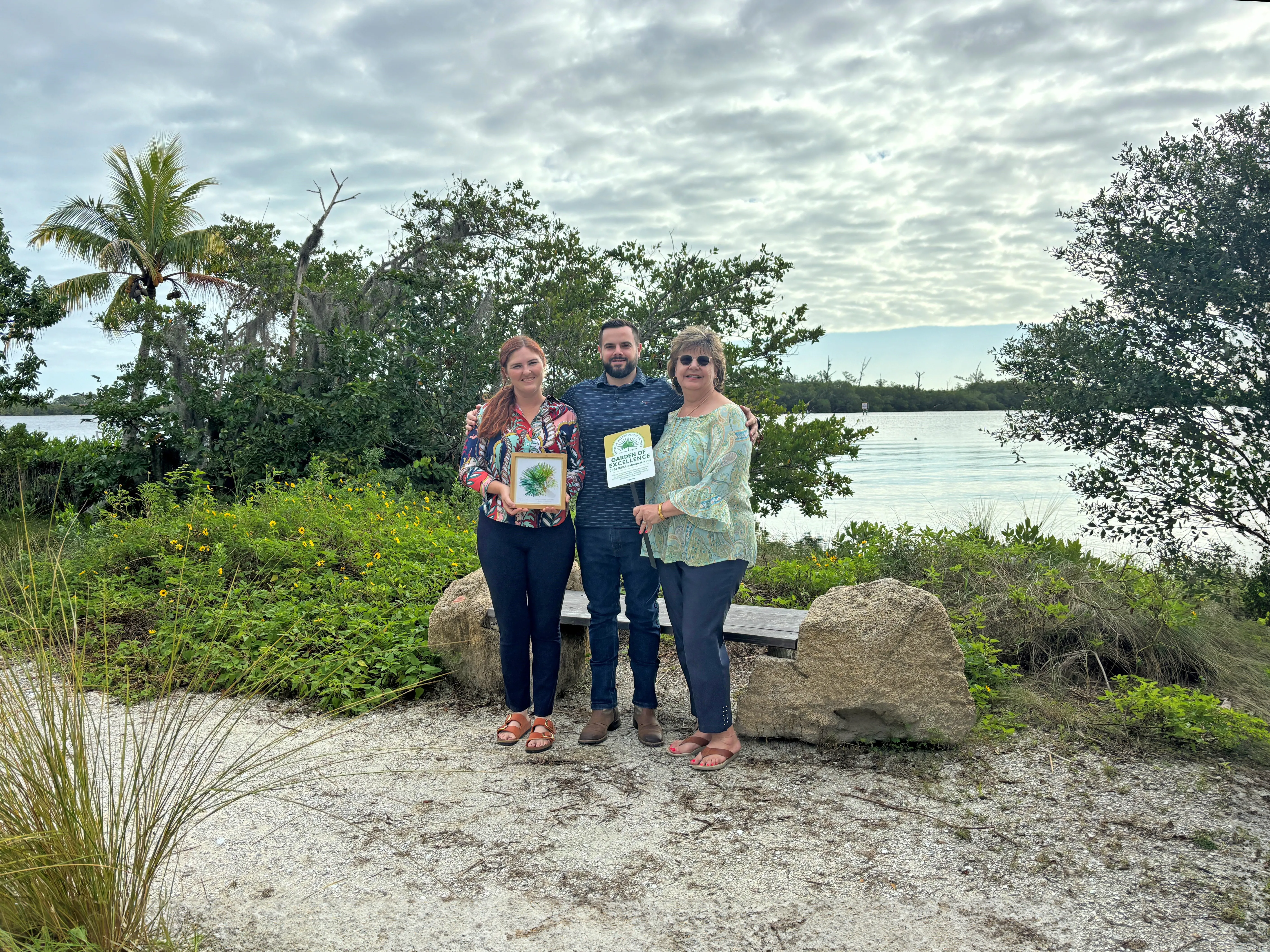 County staff posed together with the Garden of Excellence Award at the Ripple Eco-Art Project in the Old Palm City CRA.