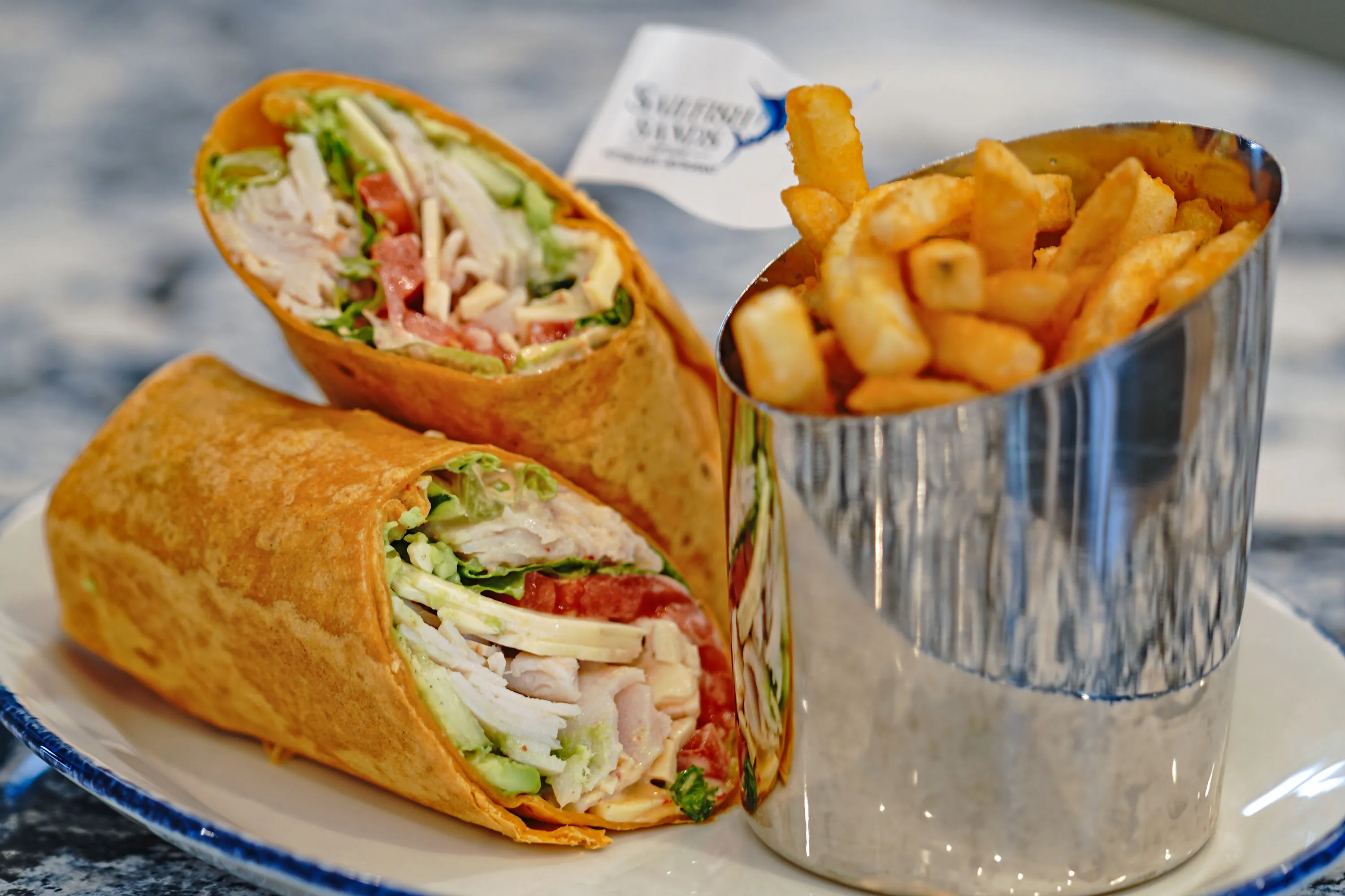 A turkey avocado wrap with a side of fries