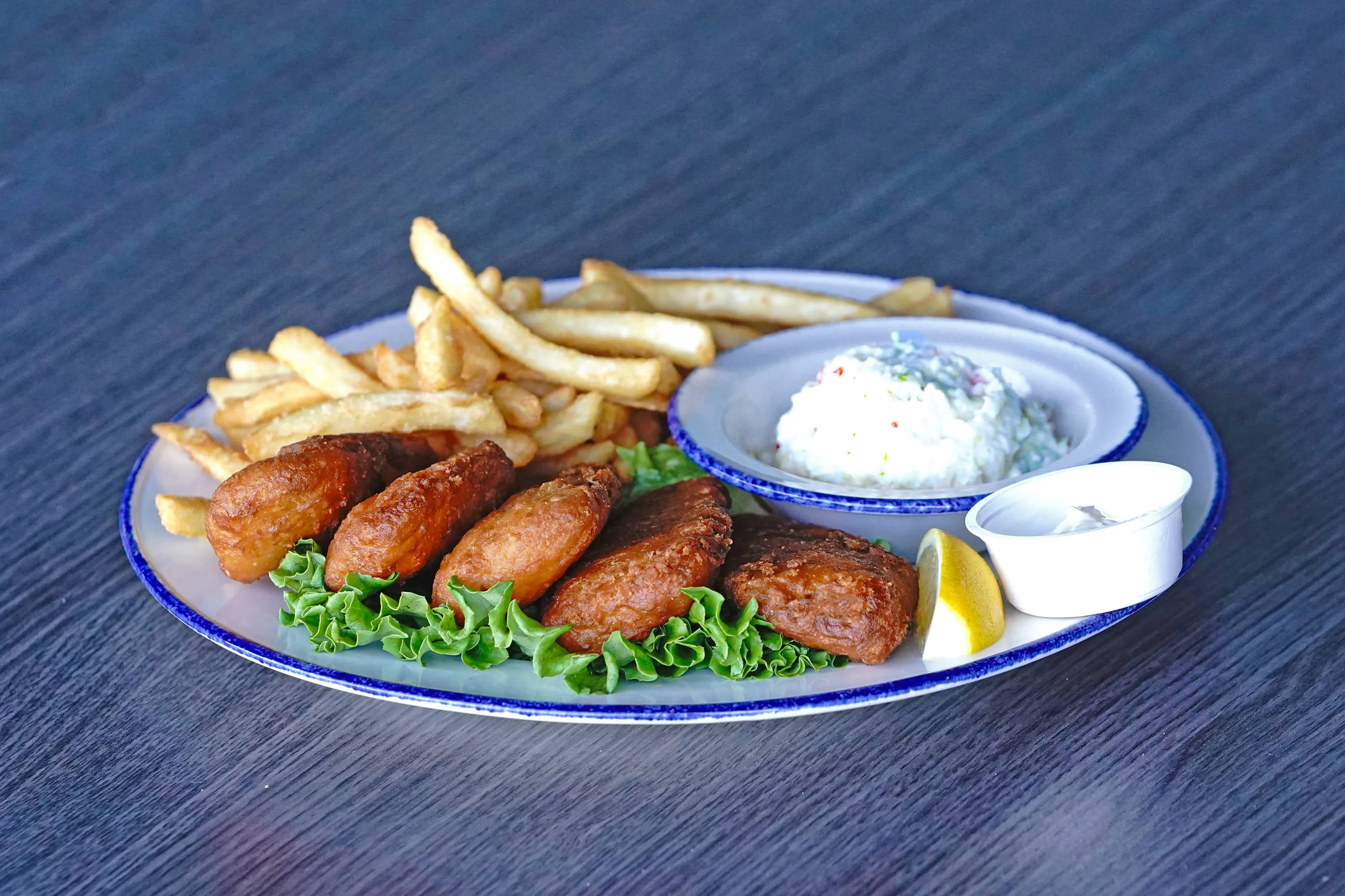 5 pieces of fried cod with a side of coleslaw and French fries