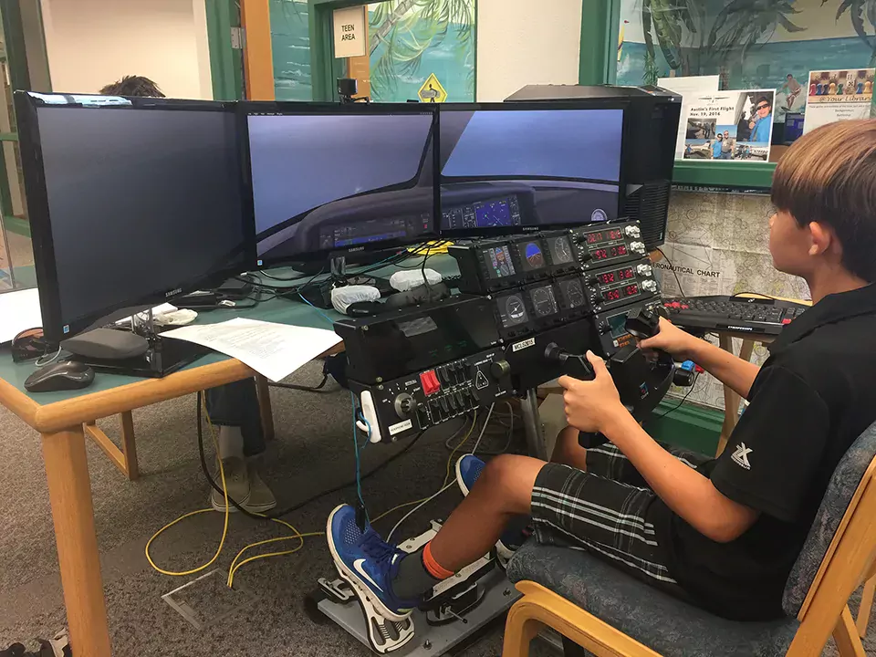 Picture of a teen using the flight simulator at the Morgade library