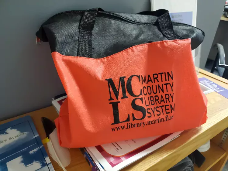 red and black delivery bag with MCLS logo Martin County Library System www.library.martin.fl.us